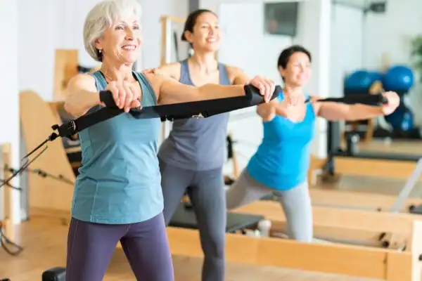 Toning Arms After 60: Empowering Womens Fitness Through Effective Weight Training 2 older woman doing weight training Southampton and resistance in the gym to tone upper arms