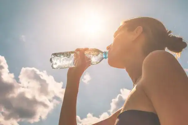 Hydration: The Secret Ingredient for a Toned Stomach and Enhanced Fitness 3 Image of woman drinking water to hydrate Southampton after run.