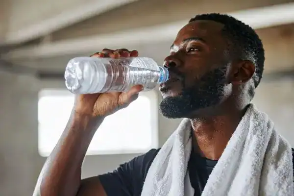 Hydration: The Secret Ingredient for a Toned Stomach and Enhanced Fitness 1 Image of man drinking water to improve hydration Southampton after work out.